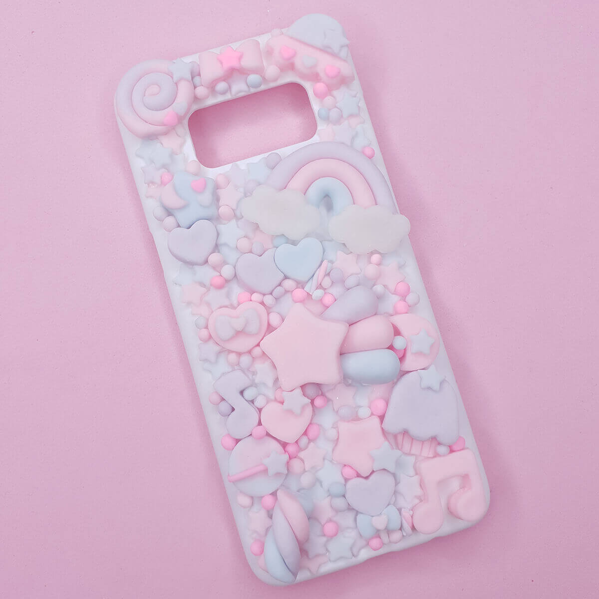 Pastel pink and blue kawaii decoden phone case with cute hearts and cloud decorations for smartphones.