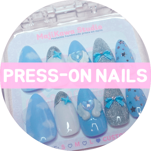Blue pill-shaped button for the Magical Kawaiiland press-on nails collection.